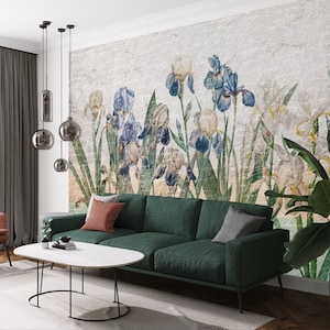 May include: A living room interior design with a green sofa, a red armchair, a white coffee table, and a wall mural featuring a vintage botanical illustration of blue and white iris flowers.