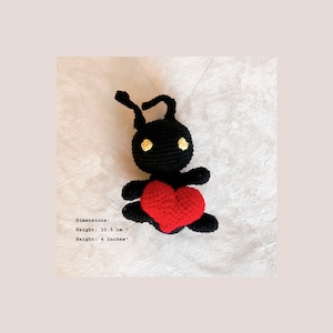 May include: Black crocheted ant holding a red crocheted heart. Dimensions: Height: 10.5 cm - Height: 4 inches.