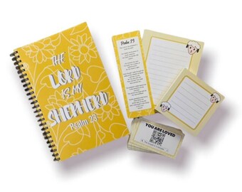 Puede incluir: Un cuaderno amarillo de espiral con el texto "The Lord is my Shepherd, Psalm 23" en la portada. El cuaderno está rodeado de blocs de notas amarillos con ilustraciones de ovejas y un marcapáginas con el texto "Psalm 23".
