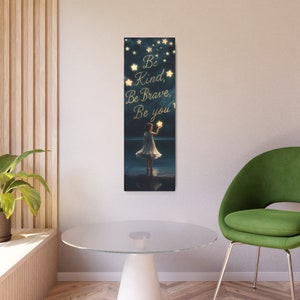 May include: A girl in a white dress stands in front of a dark blue starry sky, holding a glowing star. The text "Be Kind, Be Brave, Be You" is written in gold lettering.