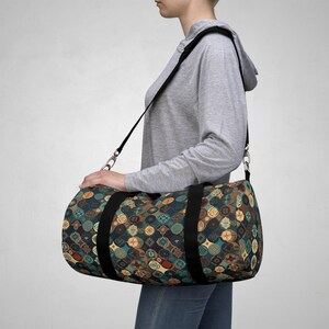 Könnte beinhalten: Zylindrische Sporttasche mit sich wiederholendem Muster aus teal, braunen und goldenen Kreisen. Sie hat schwarze Griffe und einen Schultergurt. Die Tasche wird über der Schulter getragen. Die Tasche ist aus strapazierfähigem Stoff.