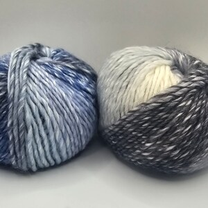 May include: Two skeins of yarn, one in shades of blue and white, the other in shades of gray and white.
