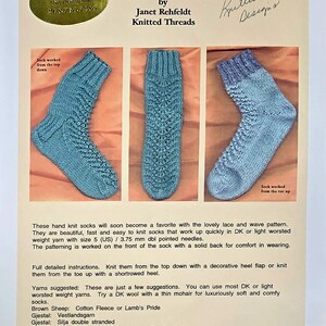 May include: A pattern for Lacy Waves Knit Socks by Janet Rehfeldt. The image shows three blue knitted socks with a detailed lace and wave pattern. The text includes instructions and yarn suggestions.
