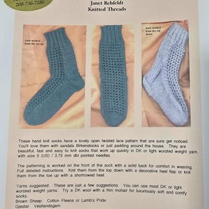 May include: A printed pattern for Twisted Lace Knit Socks by Janet Rehfeldt. The image shows three knitted socks in different stages of completion. The pattern includes instructions and yarn suggestions. The socks have a twisted lace design.