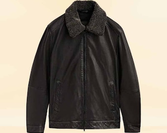 May include: A black leather jacket with a dark gray faux fur collar. The jacket has a zipper closure, two front pockets, and a quilted design on the lower front. The jacket is a classic style.