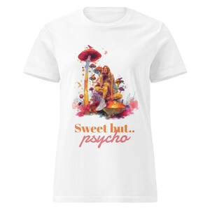 Może przedstawiać: Biała koszulka z kolorową ilustracją osoby siedzącej na grzybie, z napisem "Sweet but.. psycho" w kolorze pomarańczowym i różowym. Grafika zawiera grzyby i efekty akwareli.