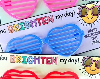 May include: Three pairs of heart-shaped sunglasses in pink, blue, and red, with horizontal slats. Each pair is on a card that says "You BRIGHTEN my day!" and "HAPPY VALENTINE'S DAY!"