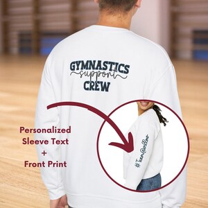May include: White sweatshirt with the text "Gymnastics support crew" on the back. The sweatshirt has a personalized sleeve text option, shown as "#TeamAwesomeness".