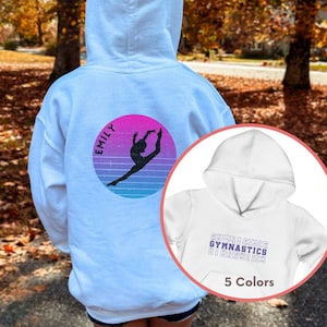 May include: White hooded sweatshirt with a pink and blue retro design featuring a gymnast silhouette and the name "Emily". The back of the sweatshirt has the word "gymnastics" repeated in a stacked pattern.