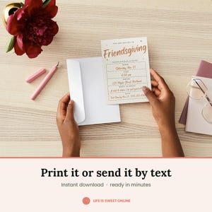May include: A rectangular Friendsgiving invitation card with copper-colored text, featuring fields for date, time, location, and RSVP details. The card is held alongside a white envelope, with a pink pen and glasses nearby on a light wood surface.