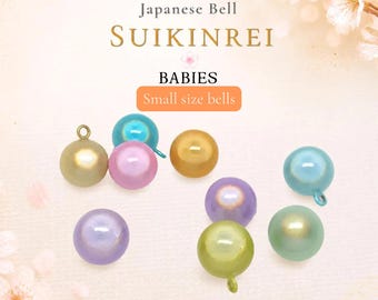 Könnte beinhalten: Eine Sammlung kleiner, kugelförmiger japanischer Suikinrei-Glocken in verschiedenen Pastellfarben wie Hellblau, Pink, Lila, Gold und Grün. Jede Glocke hat eine kleine Metallöse an der Oberseite, mit dem Text Japanese Bell SUIKINREI.