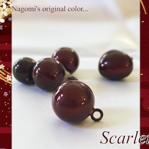 Puede incluir: Varias cuentas esféricas brillantes de color rojo oscuro con pequeños bucles están dispersas sobre una superficie blanca. La palabra "Scarlet" está escrita en cursiva en la parte inferior. El texto "Nagomi's original color..." está en la parte superior.