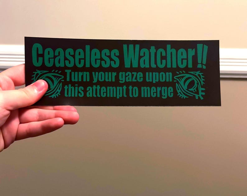 Puede incluir: Una pegatina rectangular negra con el texto verde "Ceaseless Watcher!! Turn your gaze upon this attempt to merge". La pegatina presenta dise&ntilde;os de ojos verdes a cada lado del texto.