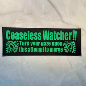 Puede incluir: Una pegatina rectangular negra con texto verde que dice "Ceaseless Watcher!!" y "Turn your gaze upon this attempt to merge". La pegatina tiene dos dise&ntilde;os de ojos verdes en la parte inferior. La pegatina est&aacute; sobre una superficie blanca y gris.