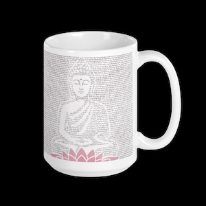May include: White ceramic mug featuring a detailed illustration of a seated Buddha composed of text. The design includes a pink lotus flower at the base. The mug has a large handle and is set against a black background.