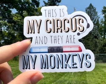 May include: A white sticker with the text "THIS IS MY CIRCUS AND THEY ARE MY MONKEYS" in black and gold lettering. The sticker also features a police light bar graphic with blue and red lights.