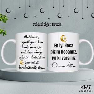 Peut inclure: Deux mugs en céramique blanche avec du texte noir et des accents dorés. L'un des mugs contient du texte en turc, l'autre du texte en turc et le nom "Osman Aluc". Les mugs sont sur une surface blanche avec un fond gris décoré de croissants de lune et d'étoiles.