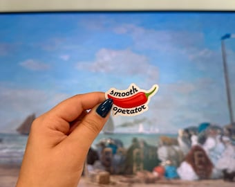May include: A red chili pepper sticker with the text "smooth operator" on a white background.