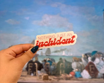 May include: A white sticker with the text "NOTHING JUST AN incident" in red letters. The sticker is being held in front of a painting of a beach scene.