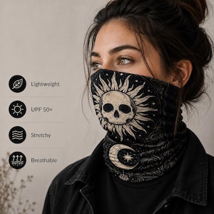 Könnte beinhalten: Ein schwarzer Schlauchschal mit einer cremefarbenen Grafik einer Sonne mit einem Totenkopf im Zentrum und einer Mondsichel. Der Stoff wird als leicht, UPF 50+, dehnbar und atmungsaktiv beschrieben. Das Design enthält himmlische Muster und Sterne.