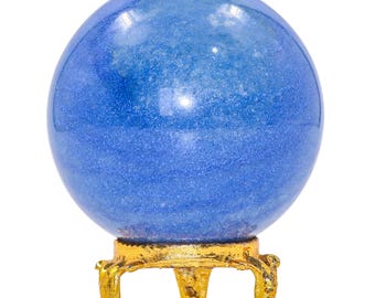 May include: A blue crystal ball with a shimmering surface, resting on a gold-colored, ornate tripod stand. The sphere is a solid, smooth orb, and the stand has a detailed, antique design. The background is plain white.