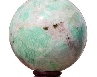 May include: A green and white sphere of polished aventurine, a type of quartz, on a dark red wooden stand.