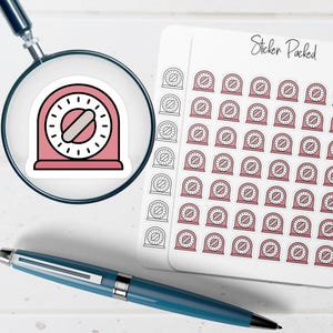 May include: A sheet of stickers with a pink kitchen timer design, and the text "Sticker Packed". The timer stickers are pink with a white dial and a gray oval. A magnifying glass and a blue pen are also in the image.