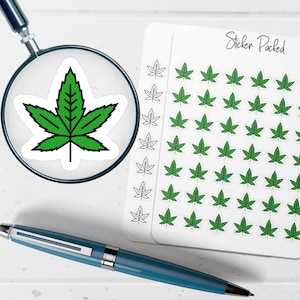 May include: A green cannabis leaf sticker is magnified by a magnifying glass. A sheet of stickers with green cannabis leaves and the text "Sticker Packed" is visible. A blue pen is in the foreground.