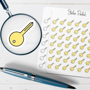 May include: A collection of key stickers, with a single key sticker magnified by a magnifying glass. The stickers are yellow with black outlines. A blue pen is in the foreground, and the words "Sticker Packed" are visible.