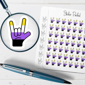 May include: A sticker sheet with multiple stickers featuring a hand gesture in the non-binary pride flag colors: yellow, purple, black, and white. A single sticker is magnified by a magnifying glass. The words "Sticker Packed" are written on the sticker sheet.