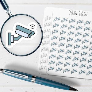 May include: A sheet of stickers featuring a security camera design, alongside a magnifying glass and a pen. The stickers are light blue and white, with a wireless symbol. The magnifying glass shows a close-up of one sticker. The pen is blue.
