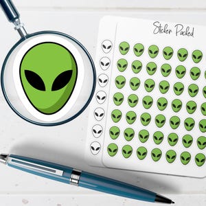May include: A collection of alien-themed stickers, featuring green alien faces with black eyes. The stickers are on a white background, with a magnifying glass and a blue pen in the image. The text "Sticker Packed" is visible.