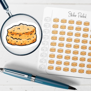 May include: A sticker sheet with multiple stickers of a biscuit, and a single biscuit sticker under a magnifying glass. The stickers are tan with dark brown details. The words "Sticker Packed" are written on the sticker sheet.
