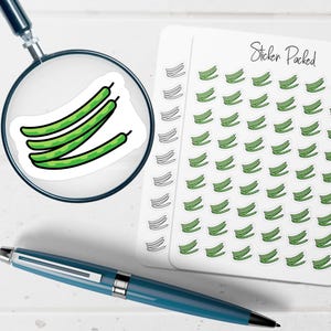 May include: A sheet of stickers featuring green bean illustrations, with the words "Sticker Packed" in cursive. A magnifying glass focuses on three green bean stickers. A blue pen rests on the surface.