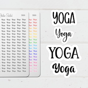 May include: White stickers with the word "YOGA" in both uppercase and script fonts. Two sheets of small stickers with the word "Yoga" repeated in various colors are also visible. The stickers are for yoga enthusiasts.