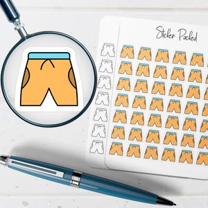 May include: A sticker sheet labeled Sticker Packed featuring multiple rows of small orange shorts with light blue waistbands and dark brown pockets, with one individual sticker magnified by a magnifying glass and a blue pen placed below.