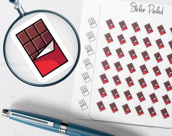 May include: A magnifying glass focuses on a chocolate bar sticker with a red wrapper. A sheet of stickers with the text "Sticker Packed" and multiple chocolate bar stickers is visible. A blue pen rests on the white surface.