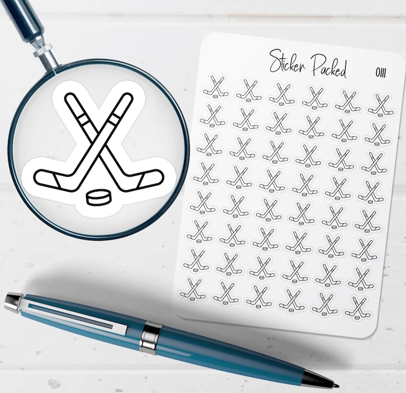 K&ouml;nnte beinhalten: Ein Bogen mit Hockey-Aufklebern mit dem Text "Sticker Packed". Die Aufkleber zeigen gekreuzte Hockeyschl&auml;ger und Pucks. Eine Lupe und ein blauer Stift sind ebenfalls im Bild.
