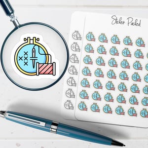 May include: A sticker sheet with multiple stickers featuring a cross-stitch design in a yellow embroidery hoop. The design includes a needle, thread, and a spool of red thread. The words "Sticker Packed" are written in black script.