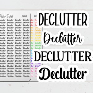 May include: A collection of white stickers with the word "Declutter" in various fonts. Some stickers are in a script font, while others are in a bold, sans-serif font. A sheet of small stickers with the word "Declutter" is also included.