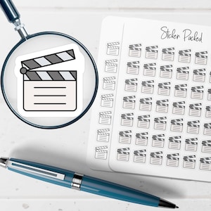 May include: A sheet of stickers featuring a film clapperboard design. The clapperboards are black, white, and gray. The sheet also has the text "Sticker Packed" in black script.