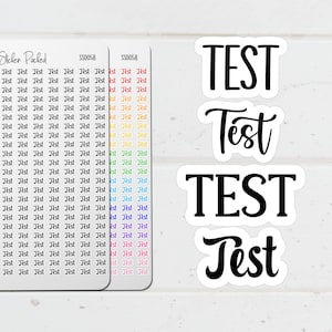 May include: White stickers with the word "TEST" in bold, black capital letters and cursive script. Two sheets of small stickers with the word "Test" repeated in various colours are also visible. The stickers are for planning and organisation.