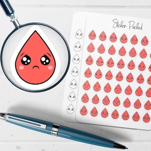 May include: A sheet of stickers with red teardrop-shaped faces with various expressions. A single sticker is magnified by a magnifying glass. The words "Sticker Packed" are written on the sticker sheet. A blue pen is in the foreground.