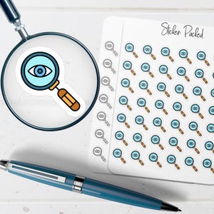 May include: A magnifying glass sticker with an eye graphic is magnified by a real magnifying glass. A sheet of stickers with the same eye magnifying glass design is next to the magnifying glass. A blue pen is also in the image.