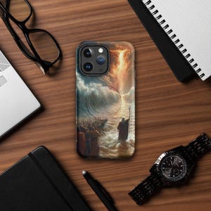 May include: A phone case featuring a biblical scene of a figure with a staff parting the sea, with a crowd of people in the foreground. The case has a black border and a glossy finish. The artwork depicts a dramatic sky with orange and blue hues.