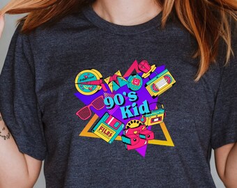 May include: A dark heather grey t-shirt with a graphic print of 90's kid with a cassette tape, sunglasses, and a video game cartridge.