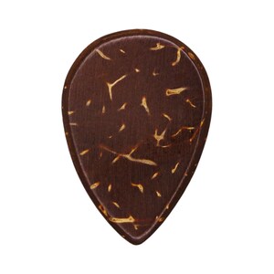 May include: A teardrop-shaped guitar pick made of dark brown material with a natural, textured appearance. The pick has a smooth, rounded edge and is speckled with lighter brown and tan markings.