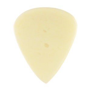 May include: A cream-colored guitar pick with a slightly rounded point.