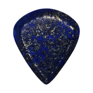 May include: A polished, teardrop-shaped gemstone with a deep blue hue, speckled with shimmering gold flecks. The stone has a smooth, reflective surface and is set against a plain white background. This gemstone is likely a lapis lazuli.