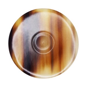 May include: A round, brown and cream colored dish with a small, round indentation in the center. The dish is made of a natural material with a swirling pattern.